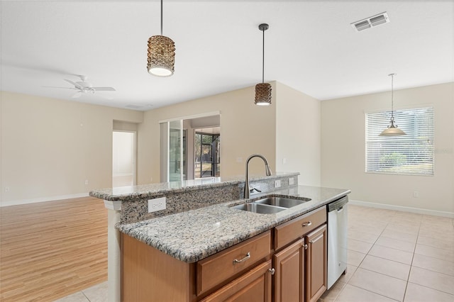 kitchen with stainless steel dishwasher, decorative light fixtures, and sink