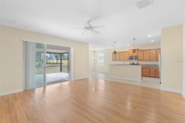 unfurnished living room with ceiling fan and light hardwood / wood-style floors