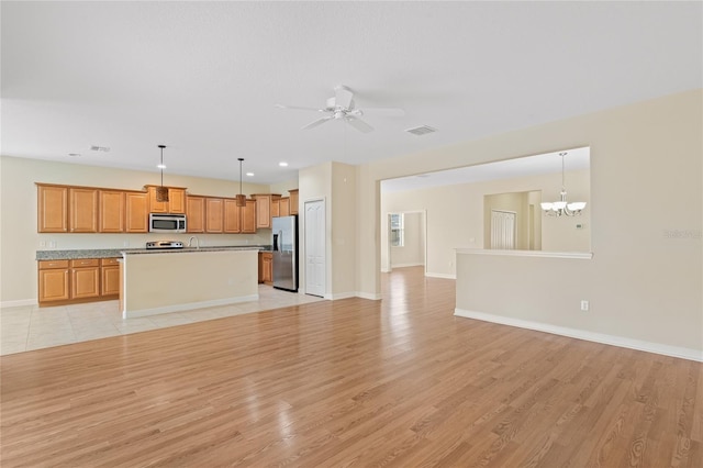 unfurnished living room with sink, ceiling fan with notable chandelier, and light hardwood / wood-style floors