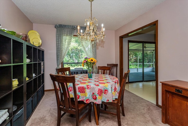 dining room with a textured ceiling, light carpet, and a chandelier