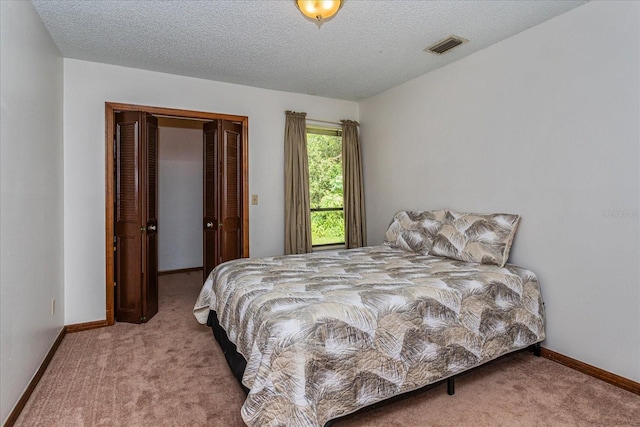 carpeted bedroom featuring a textured ceiling