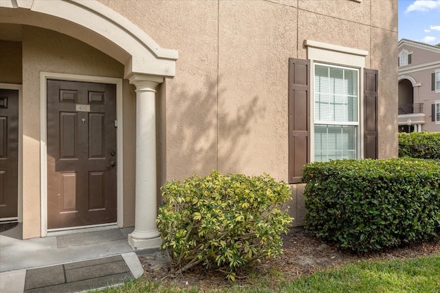 doorway to property featuring stucco siding