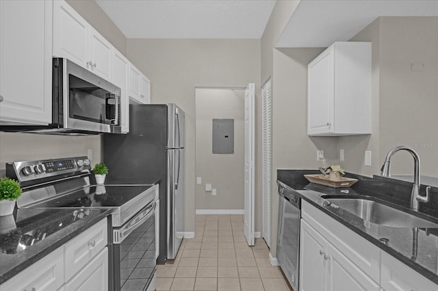 kitchen featuring light tile patterned floors, appliances with stainless steel finishes, white cabinetry, a sink, and electric panel