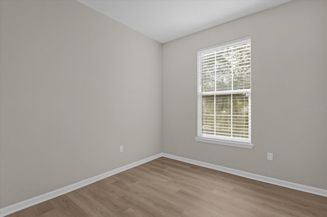 spare room featuring light wood-type flooring and baseboards