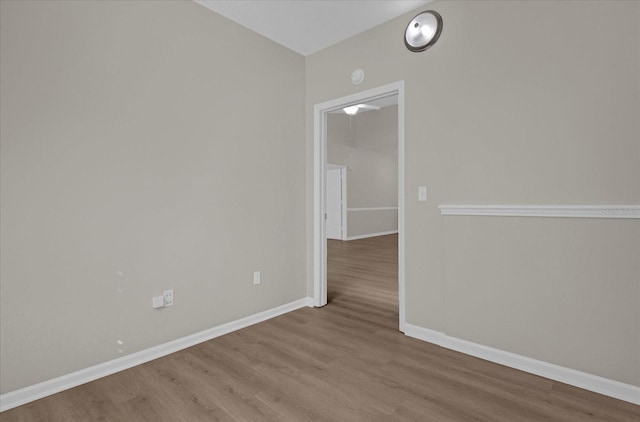 unfurnished room with baseboards and wood finished floors