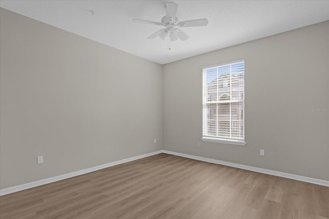 empty room with light wood-type flooring, ceiling fan, and baseboards