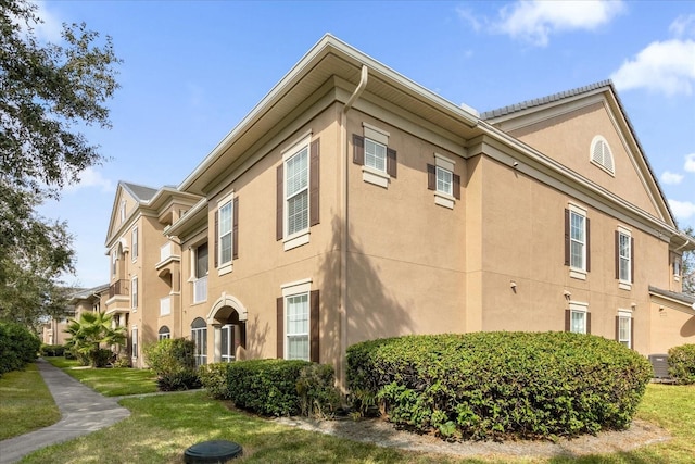 14304 Fredricksburg Dr Unit 420, Orlando, FL 32837 - view of home's exterior with stucco siding and a yard