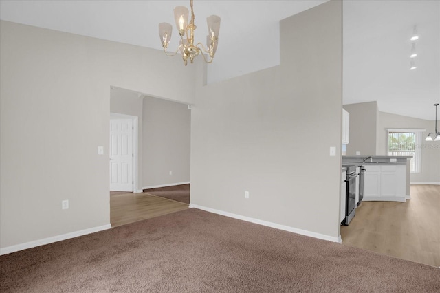 interior space with hardwood / wood-style floors, lofted ceiling, and an inviting chandelier