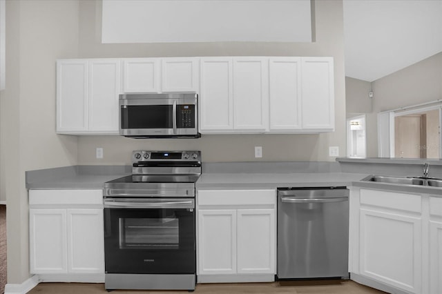 kitchen with sink, white cabinets, and appliances with stainless steel finishes