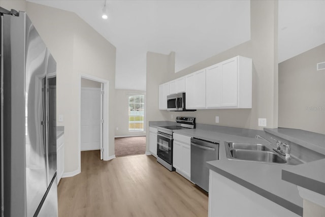 kitchen with stainless steel appliances, sink, high vaulted ceiling, white cabinets, and light hardwood / wood-style floors