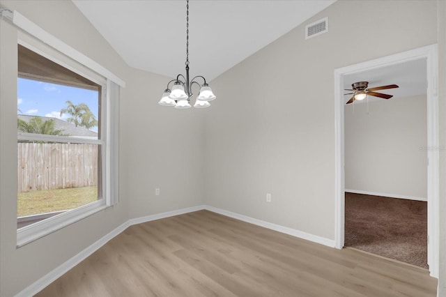 unfurnished room with a wealth of natural light, vaulted ceiling, and light wood-type flooring