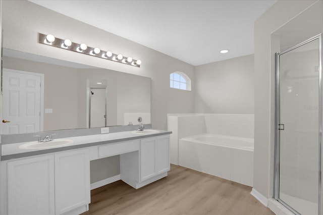 bathroom featuring plus walk in shower, hardwood / wood-style floors, and vanity