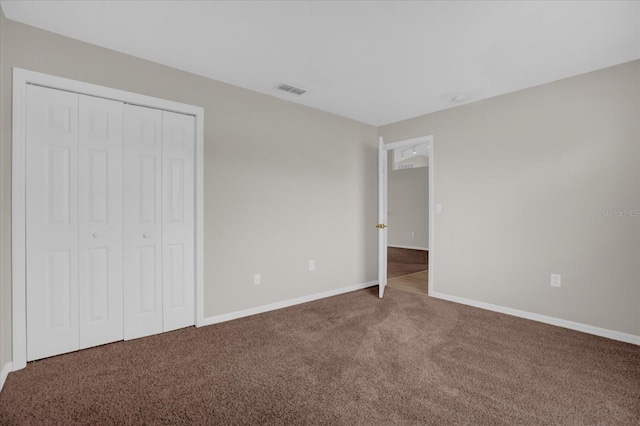 unfurnished bedroom with carpet floors and a closet