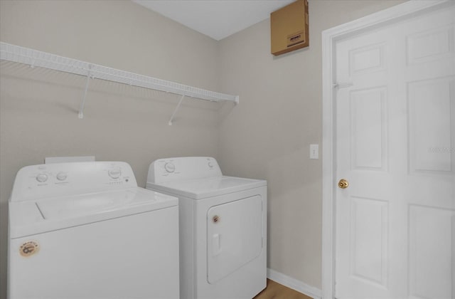 laundry room with washer and clothes dryer and wood-type flooring