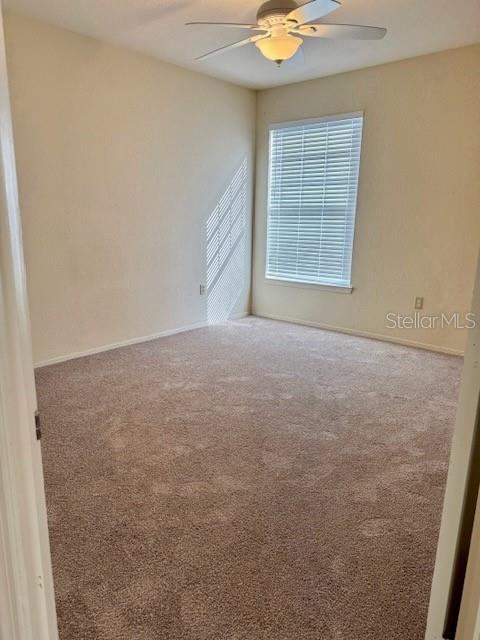 carpeted empty room with ceiling fan