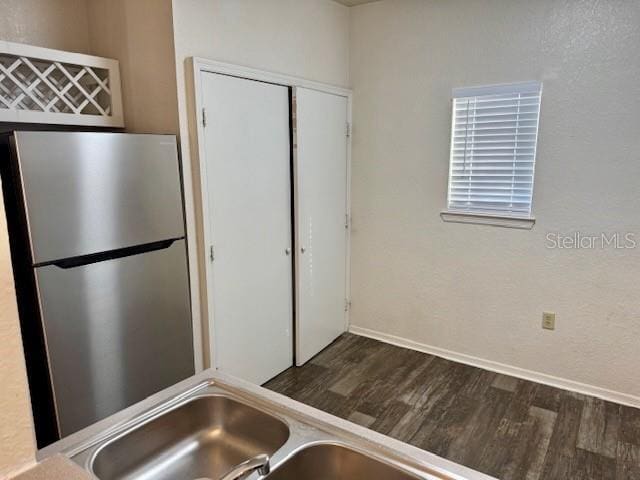 kitchen featuring stainless steel fridge and dark wood-type flooring