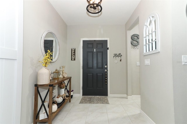 entrance foyer featuring light tile patterned floors and an inviting chandelier