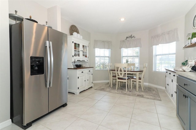 kitchen with gray cabinets, stainless steel fridge, white cabinets, and light tile patterned floors