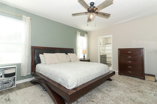 bedroom featuring ceiling fan, ensuite bathroom, and light wood-type flooring