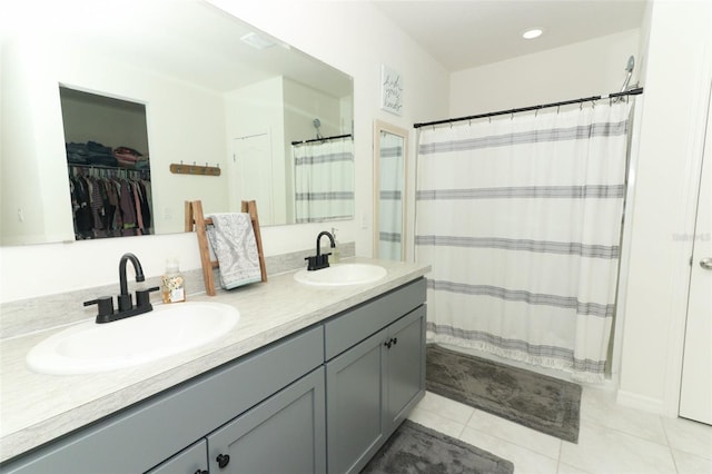 bathroom with tile patterned flooring, vanity, and walk in shower