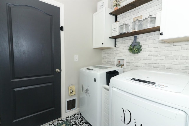 washroom with washer and clothes dryer and cabinets