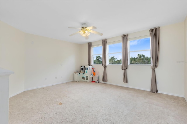 unfurnished room with ceiling fan and light colored carpet