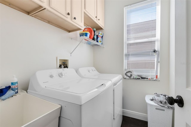 clothes washing area featuring cabinets, washing machine and dryer, and sink