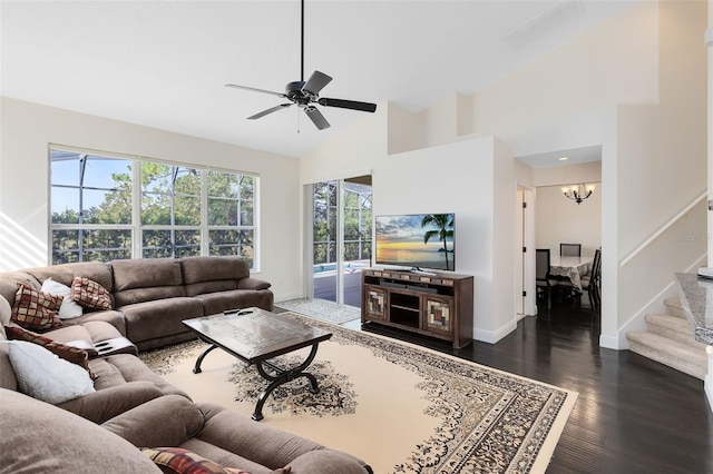 living room with ceiling fan with notable chandelier, dark hardwood / wood-style flooring, and high vaulted ceiling