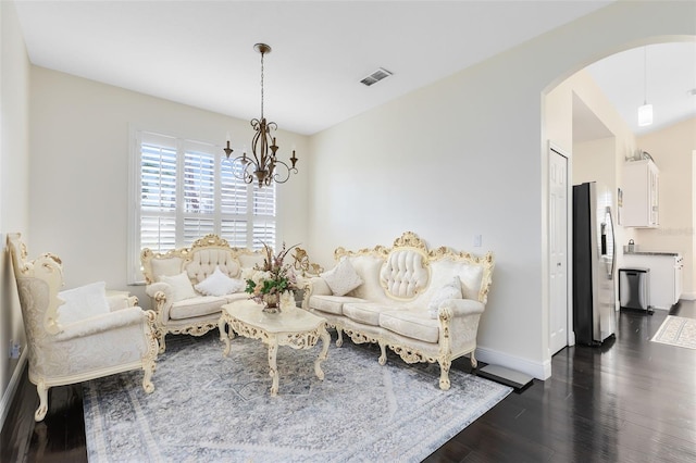 living room featuring a notable chandelier and dark wood-type flooring