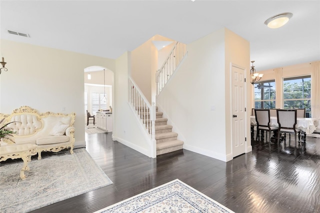 entryway with plenty of natural light, dark hardwood / wood-style flooring, and a chandelier