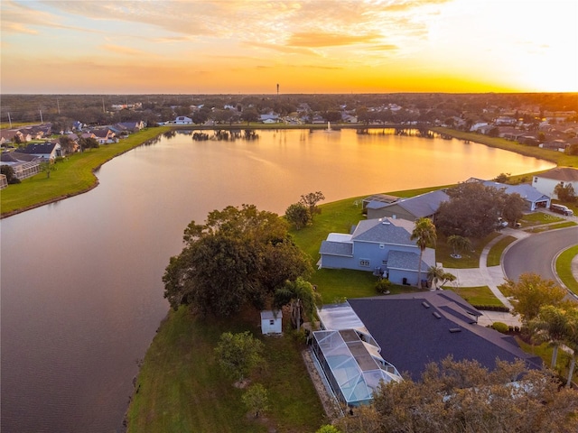 aerial view at dusk featuring a water view