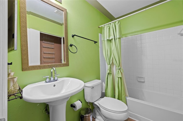 full bathroom featuring shower / bath combo with shower curtain, toilet, and sink