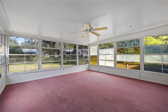 unfurnished sunroom featuring a wealth of natural light, ceiling fan, and vaulted ceiling