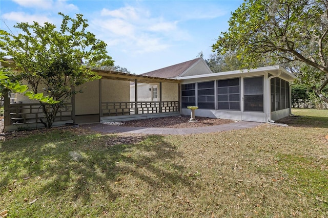 rear view of house with a sunroom and a yard