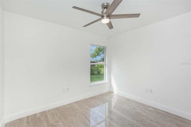 empty room with ceiling fan and light hardwood / wood-style floors