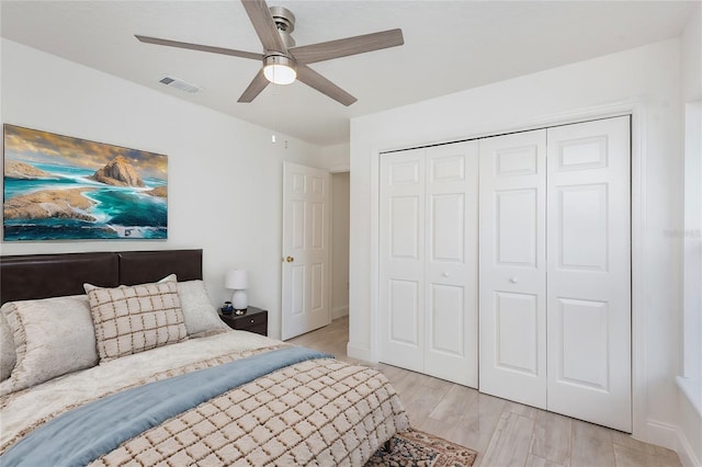 bedroom featuring ceiling fan, a closet, and light wood-type flooring