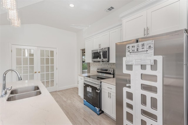 kitchen featuring sink, french doors, stainless steel appliances, white cabinets, and light wood-type flooring