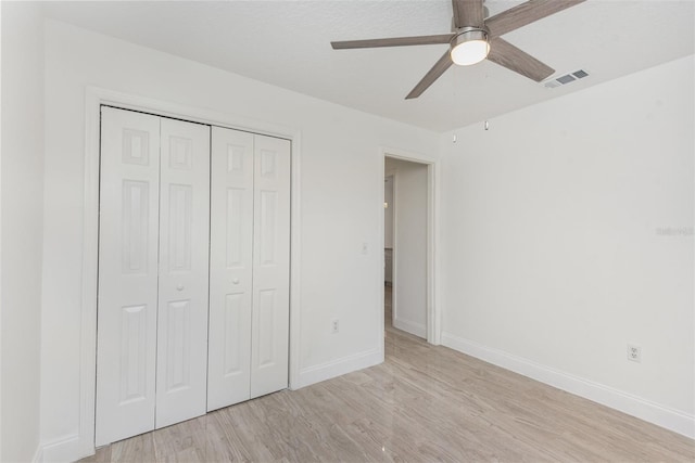 unfurnished bedroom with ceiling fan, light hardwood / wood-style floors, and a closet