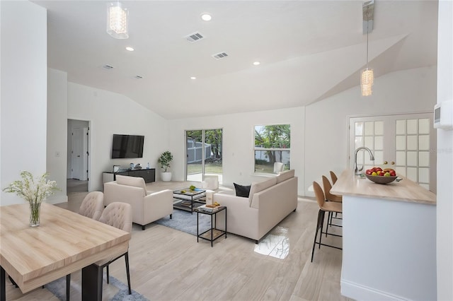 living room with light hardwood / wood-style floors and vaulted ceiling