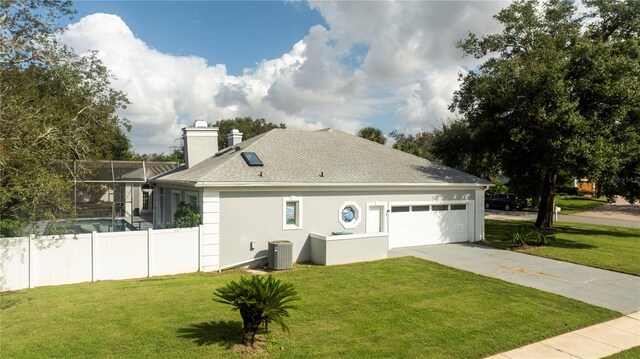 view of side of home with a lawn, central air condition unit, and glass enclosure