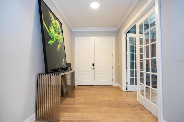 hall with crown molding, french doors, and light hardwood / wood-style floors