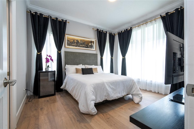 bedroom with wood-type flooring and ornamental molding