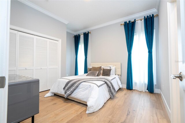 bedroom featuring hardwood / wood-style floors, crown molding, and a closet