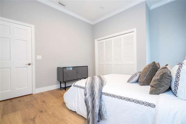 bedroom with hardwood / wood-style flooring, a closet, and ornamental molding