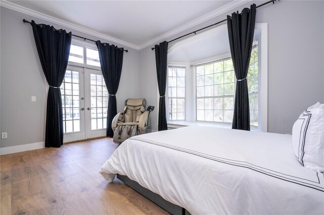 bedroom with access to exterior, wood-type flooring, french doors, and ornamental molding