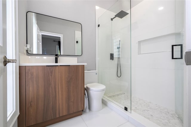 bathroom with tile patterned floors, a shower with door, vanity, and toilet