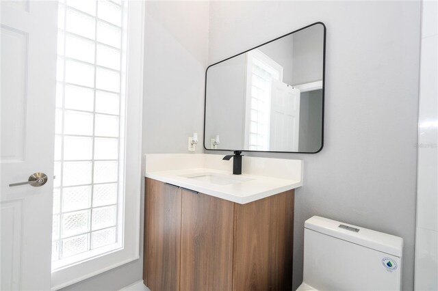 bathroom with vanity, toilet, and a wealth of natural light