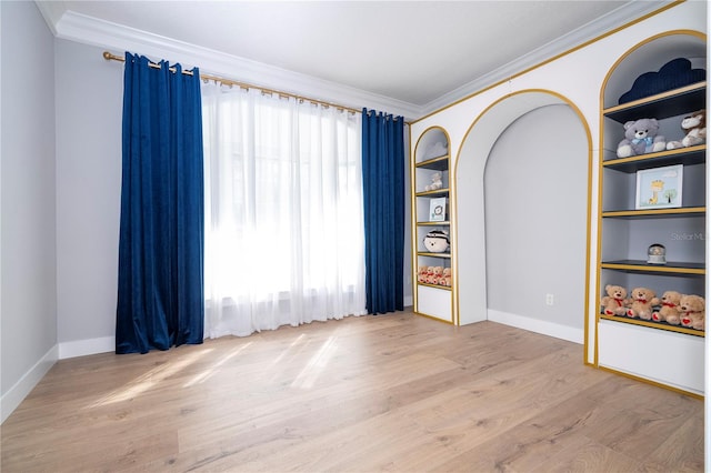 spare room with plenty of natural light, crown molding, and light hardwood / wood-style flooring