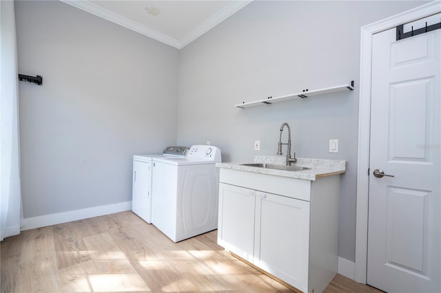 clothes washing area with washer and clothes dryer, crown molding, sink, and light wood-type flooring