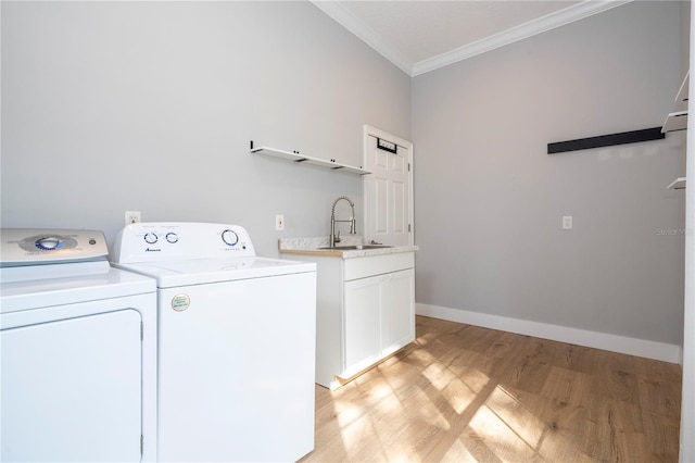 clothes washing area with sink, cabinets, separate washer and dryer, light hardwood / wood-style floors, and ornamental molding